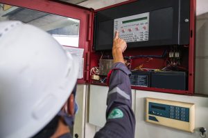 Engineer servicing a fire alarm system as part of statutory maintenance