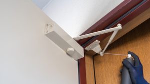 Checking a fire door closes correctly during a site compliance walk