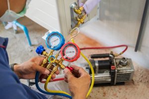 Engineer servicing air conditioning, an example of what is considered property maintenance